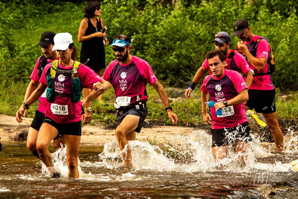 Los atletas superan el río en la carrera Alpax2 2021.